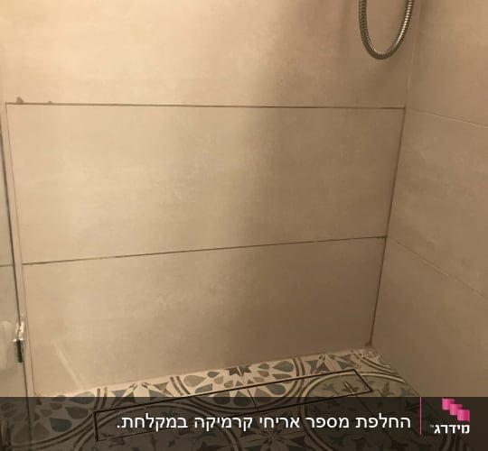 מקלחת עם אריחים מעוצבים וצינור מתכת